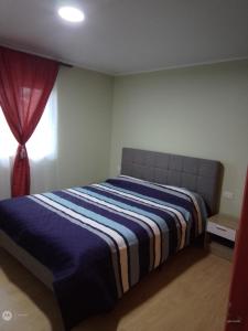 een slaapkamer met een blauw en wit bed en een raam bij Apartamento en pto Montt in Puerto Montt