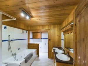 2 lavabos y baño con bañera y paredes de madera en Appartement Montvalezan-La Rosière, 6 pièces, 11 personnes - FR-1-398-655 en Montvalezan