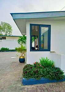 a house with two potted plants and a window at Harmony Park, East Cantonments, Accra in Accra