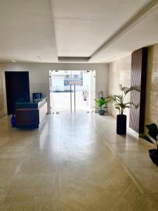 an empty room with a lobby with potted plants at Harmony Park, East Cantonments, Accra in Accra