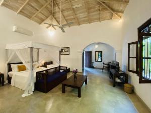 a bedroom with a bed and a couch and a table at Ceylon Olive Galle in Galle