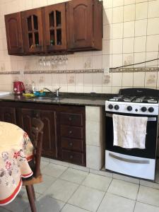 cocina con fogones, fregadero y mesa en J & S Casa de Alquiler Temporario en Santiago del Estero