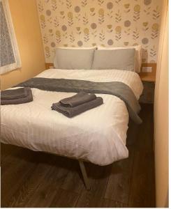 a bedroom with two beds with towels on them at Family or couple 3-bed cosy home with fireplace, 50 deposit required, self-catering in Hastings