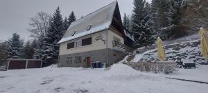 a house in the snow with a pile of snow at Penzion Svojanov in Svojanov