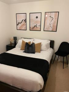 um quarto com uma cama grande com quatro quadros na parede em Great 1Bed 10 mins from East Croydon with Free parking em Croydon