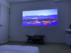 TV colgada en la pared de un dormitorio en Villa Awase 111, en Okinawa City