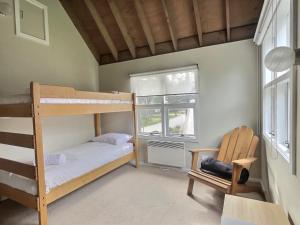 a bedroom with two bunk beds and a chair at Meltdown, alpine-getaways in Dinner Plain