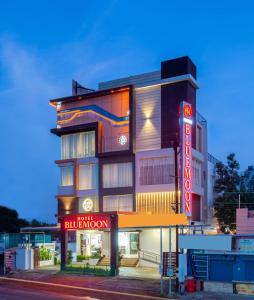 a hotel building with a neon sign in front of it at HOTEL BLUEMOON in Tirunelveli