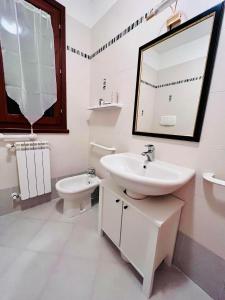 a bathroom with a sink and a toilet and a mirror at Locazione Turistica Casa LALLI in Pieve a Maiano