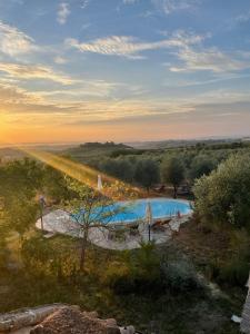 an overhead view of a swimming pool with the sun setting at La Falconara in Montepulciano