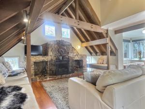a living room with a large stone fireplace at Meltdown, alpine-getaways in Dinner Plain
