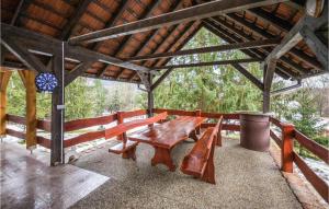 une table en bois et des bancs dans un pavillon dans l'établissement Gorgeous Home In Novo Zvecevo With Wifi, à Novo Zvecevo