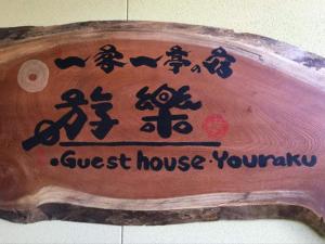 un cartel de madera con un cartel de la casa de huéspedes. en 一客一亭の宿 遊楽, en Satsumasendai