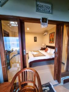 Habitación pequeña con cama y balcón. en Lembongan Made Inn, en Nusa Lembongan