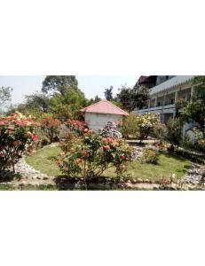 a picture of a garden with flowers and a building at Moon Hotel And Restaurant,Ranikhet in Rānīkhet