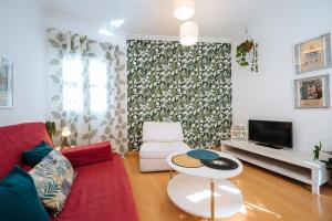 sala de estar con sofá rojo y mesa en Precioso Apartamento San Juan de la Palma, Parking Optional, en Sevilla
