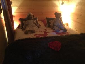 dos ositos de peluche sentados en una cama en Chalet pour 2 amoureux, en Allinges