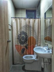 a bathroom with a toilet and a sink with a sunflower shower curtain at Legasi 3-bedroom condo - 5 mins walk to KLCC in Kuala Lumpur +19 photos