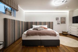 a bedroom with a bed with a striped wall at Casa 51 by Tine in Altenmarkt im Pongau