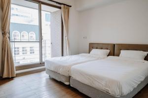 a bedroom with a large bed and a large window at LAR Suite in Taichung