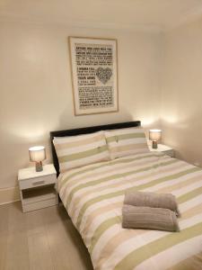 a bedroom with a bed with two night stands and two lamps at Heronsgate GH009 in Abbey Wood