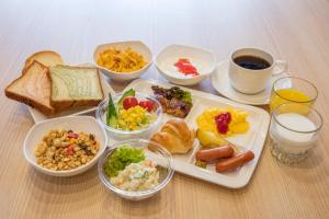 una bandeja de alimentos con diferentes tipos de alimentos para el desayuno en Sotetsu Fresa Inn Kyoto-Hachijoguchi, en Kioto