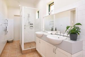 a white bathroom with two sinks and a shower at Island Brook Estate Vineyard and Chalets in Yelverton