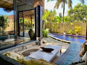 a patio with a table and a swimming pool at Unique Balian beach house in Antasari