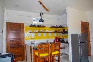 a kitchen with yellow walls and a counter top at Hotel Happy Beach in Zihuatanejo