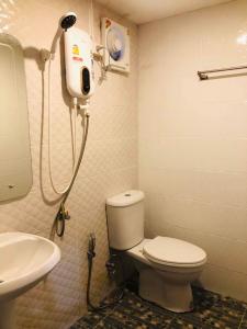 La salle de bains est pourvue de toilettes blanches et d'un lavabo. dans l'établissement กอบสุข รีสอร์ท2 k13, à Ban Ton Liang