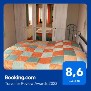 a bedroom with a bed with an orange and blue quilt at Im Sternhaus Waren Müritz in Waren