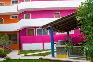 a colorful building with a pink at Hotel Happy Beach in Zihuatanejo
