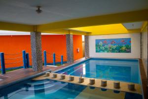 een zwembad met een aquarium in een gebouw bij Hotel Happy Beach in Zihuatanejo