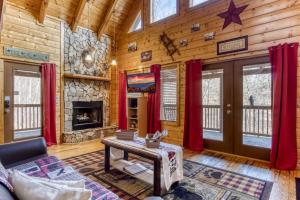 a living room with a fireplace in a log cabin at Papa's Bear Nest in Sevierville