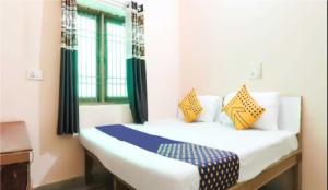 a bedroom with a bed with yellow and blue pillows at Om Sai Nath Lodge By WB Inn in Agra