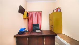 an office with a wooden desk with a laptop on it at Om Sai Nath Lodge By WB Inn in Agra