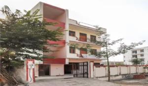 a building with a tree in front of it at Om Sai Nath Lodge By WB Inn in Agra