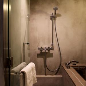 a bathroom with a shower and a bath tub at arita huis in Arita