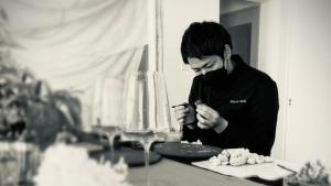 a man standing at a table looking at his cell phone at arita huis in Arita