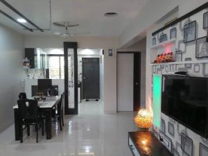 cocina y comedor con mesa y TV en Vista Manor - 3 BHK with pool-1.5 hrs from Mumbai, en Pālghar