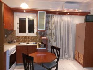 a kitchen with a wooden table and a table and chairs at Ιάνθη studio in Karditsa