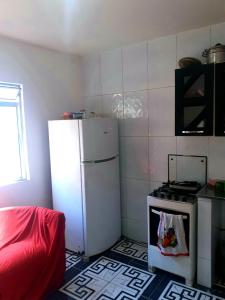a kitchen with a white refrigerator and a stove at Casa para temporada in Salvador