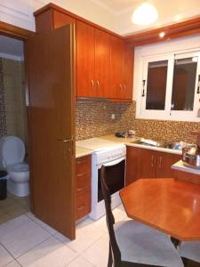 a kitchen with wooden cabinets and a table and a sink at Ιάνθη studio in Karditsa