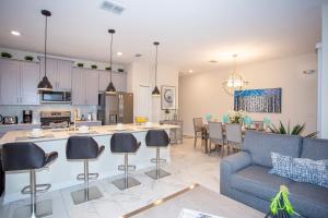 a kitchen and living room with a couch and a table at Marvelous 4 Bd w/ Pool Close to Disney 218 in Kissimmee