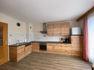 une cuisine avec des placards en bois et un comptoir noir dans l'établissement Ferienhaus Bergwelt, à Liesing