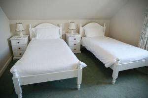 艾薩克港的住宿－Haven Cottage, Port Isaac Bay Holidays，卧室内的两张床,配有白色床单和枕头