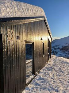 un edificio de madera con nieve. en Cabin at the top of Hodlekve. Ski in/ski out. en Sogndal