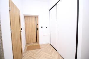 a hallway with white walls and a door at Apartament Przytulny in Szczawno-Zdrój