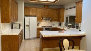 a kitchen with wooden cabinets and a white refrigerator at Beautiful peaceful desirable home in Madera Rancho in Madera