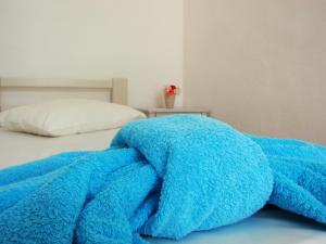 eine blaue Decke, die auf einem Bett liegt in der Unterkunft Pavlosx2 in Folegandros Chora